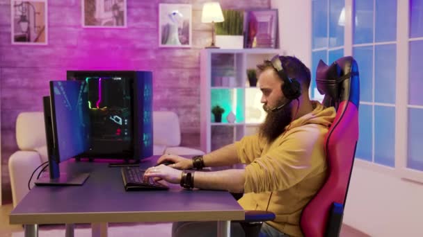 Man sitting on a gaming chair and playing video games in his room — Stock Video