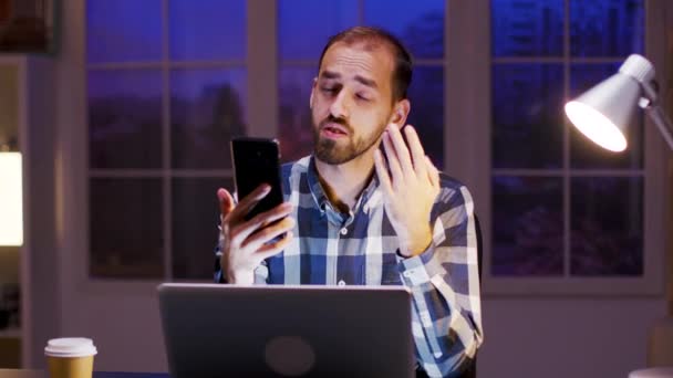 Caucasian entrepreneur talking during a video call on his phone — ストック動画