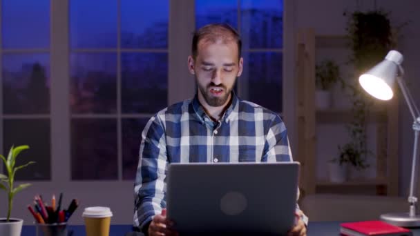 Caucasian entrepreneur talking during a video call on his laptop — ストック動画