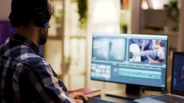 Kulaklıklı film yapımcısı bir filmin renkleri üzerinde çalışıyor.