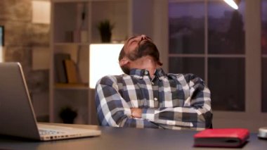 İş adamı ofiste koltukta uyuyor.