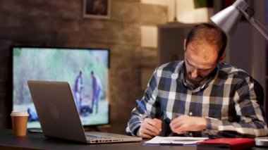 Sakallı işadamı, gece geç saatlerde ofis masasında oturuyor.