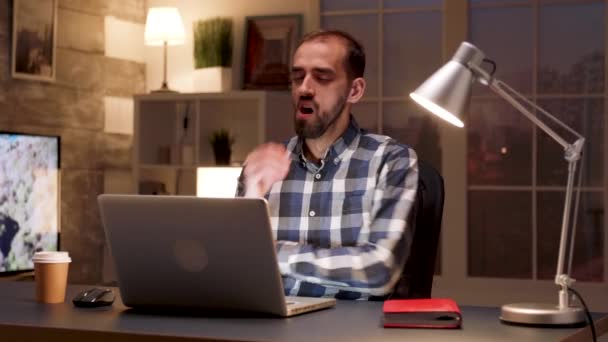 Уставший менеджер зевает перед ноутбуком — стоковое видео