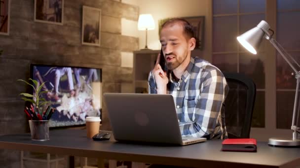 Entrepreneur taler på mobiltelefon, mens du arbejder på laptop – Stock-video