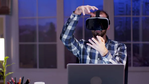 Jovem empresário usando óculos de realidade virtual à noite em seu escritório em casa — Fotografia de Stock