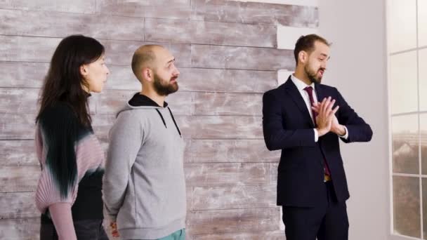 Fastighetsmäklare i kostym presenterar ny lägenhet — Stockvideo