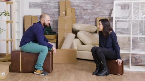 Пара розмовляє і сидить на валізах після перенесення коробок — стокове відео