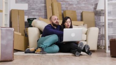 Yeni dairenin zemininde oturan çift.