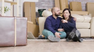 Kafkasyalı genç çift yeni dairelerinin zemininde oturuyor.