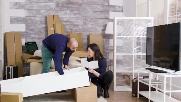 Caucasian young couple in new apartment assembling furniture — Stock Video