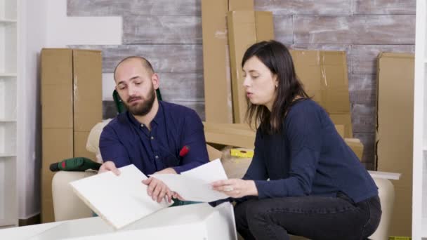 O par lê instruções da reunião da mobília na nova casa — Vídeo de Stock