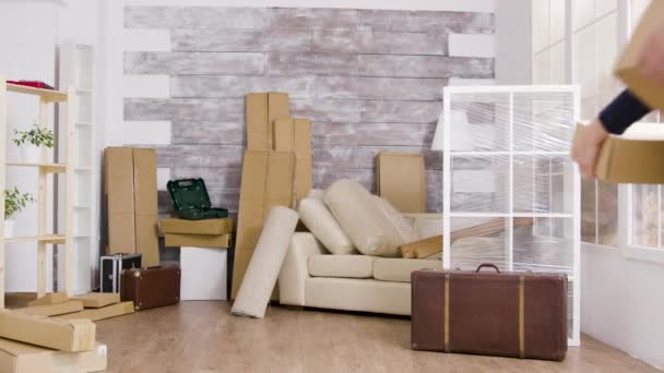 Junges Paar trägt Kisten in seiner neuen Wohnung — Stockvideo