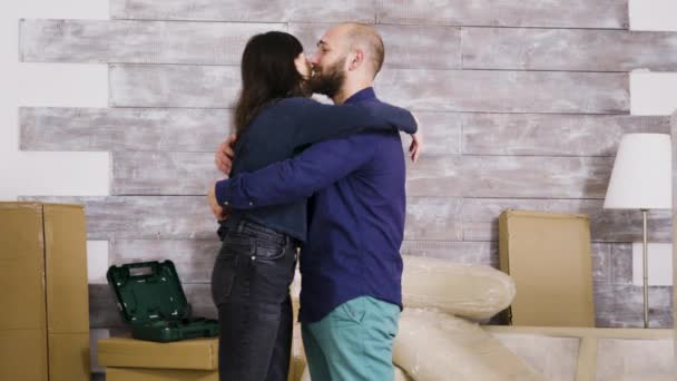 Feliz jovem casal abraçando uns aos outros em seu novo apartamento — Vídeo de Stock