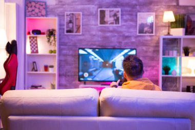 Televizyonda nişancı oyunları oynayan bir adamın arka planı