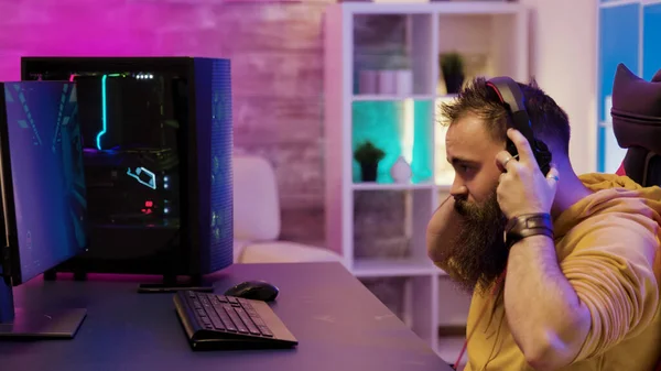 Geconcentreerde man speelt videospelletjes op pc in zijn kamer — Stockfoto