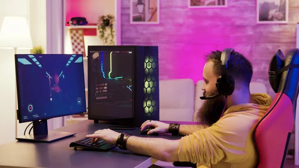 Bearded man playing online video games on his pc — Stock Photo, Image