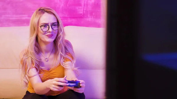 Beautiful blonde girl upset because she lost while playing video games — Stock Photo, Image