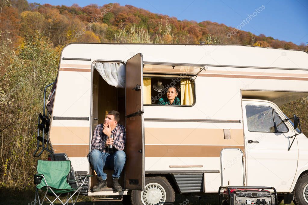 Couple admiring nature from inside of their retro camper van