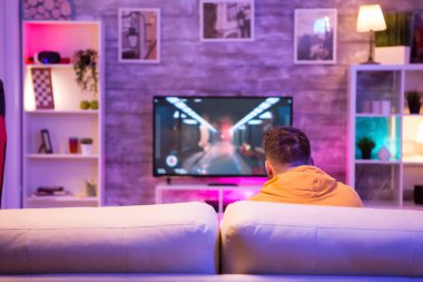 Televizyonda video oyunu oynayan genç adamın arka planı
