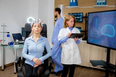 Doktor, bir kızın beynini tarama prosedürünü takip ediyor.
