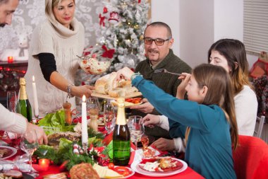 Genç anne Noel arifesinde ekmeği kızına uzatıyor.