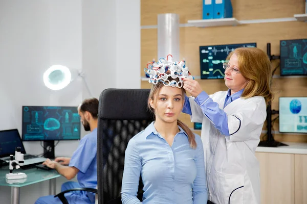 Médico organizando ondas cerebrais digitalização headset para um paciente — Fotografia de Stock