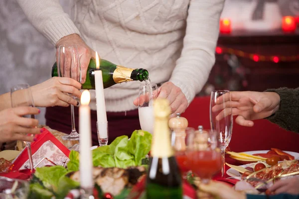 Primo piano dell'uomo adulto che versa champagne in un bicchiere alla celebrazione di Natale con la sua famiglia — Foto Stock