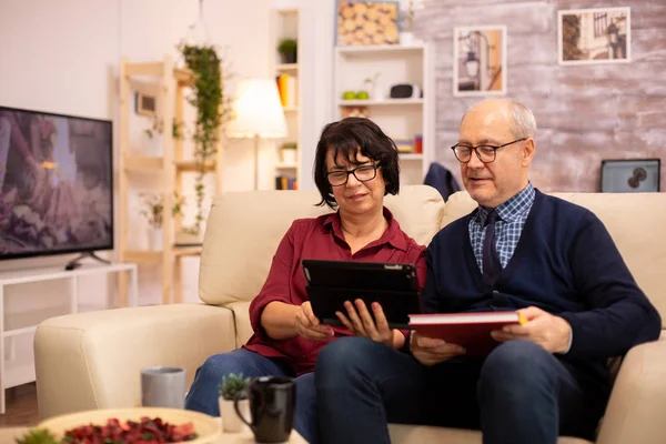 Mooi oud paar met behulp van een digitale tablet om te chatten met hun familie — Stockfoto