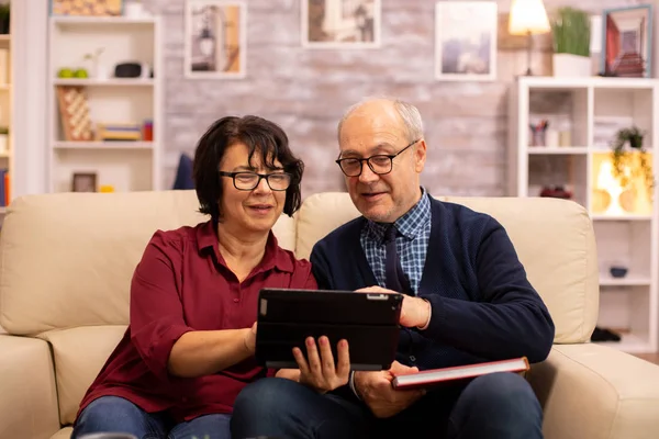 Mooi oud paar met behulp van een digitale tablet om te chatten met hun familie — Stockfoto