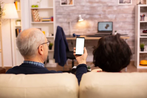 Zadní pohled na starší důchodce pár při pohledu na smartphone s bílou izolovanou obrazovkou — Stock fotografie