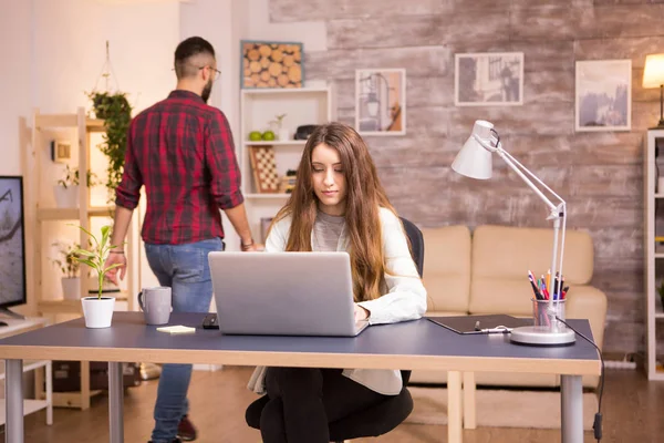 Jovem freelancer do sexo feminino trabalhando no laptop no escritório em casa — Fotografia de Stock