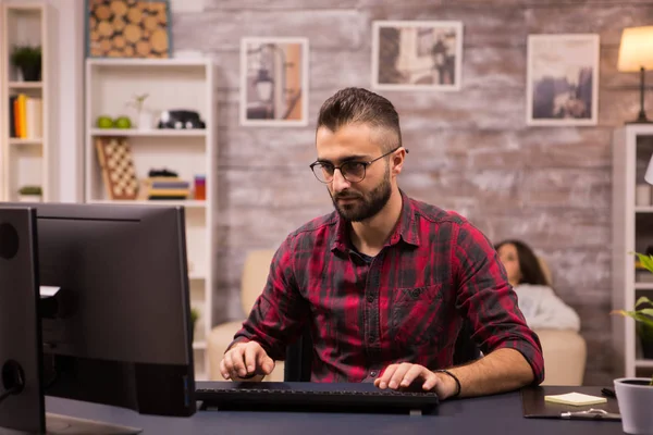Joven freelancer enfocado mientras trabaja en el ordenador desde casa — Foto de Stock