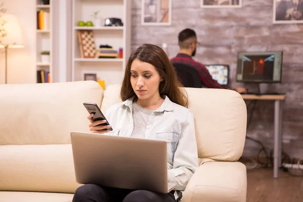 Красива молода жінка сидить на дивані з ноутбуком — стокове фото