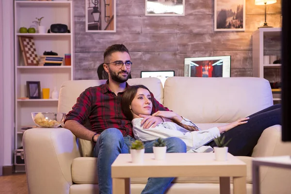 Belo jovem casal assistindo seu programa de tv favorito — Fotografia de Stock