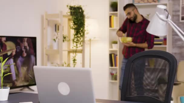 Девушка наслаждается чашкой кофе во время работы на ноутбуке в гостиной — стоковое видео