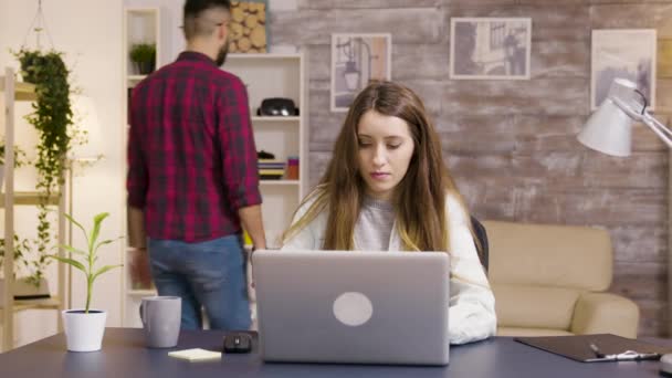 美しい若い女性は自宅のオフィスでノートパソコンで作業 — ストック動画