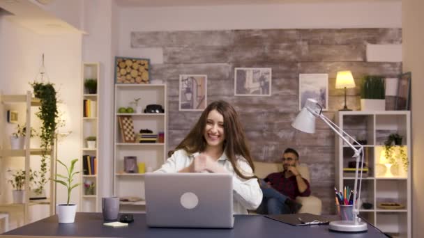 Jovem excitada na frente do laptop enquanto trabalhava na sala de estar — Vídeo de Stock