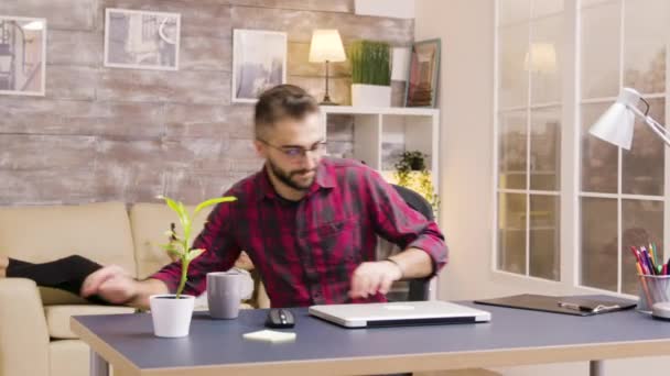 Yakışıklı serbest çalışanın oturma odasında laptop açtığı görüntüyü yakınlaştır. — Stok video