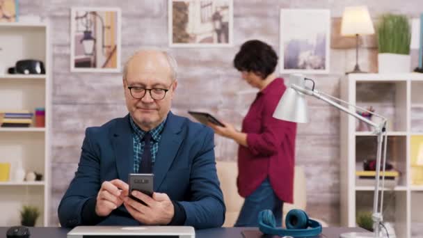 Homme âgé avec lunettes naviguant sur téléphone portable — Video