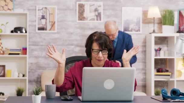 Mujer vieja asombrada después de leer una noticia en el ordenador portátil — Vídeos de Stock