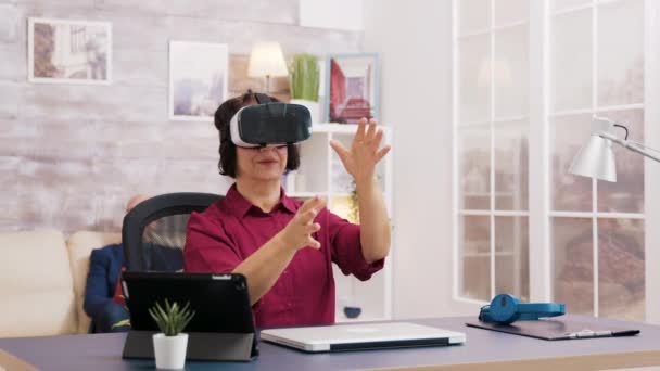 Mulher idosa usando óculos de realidade virtual na sala de estar — Vídeo de Stock