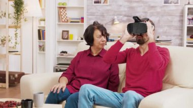 Yeğen, büyükannesine VR gözlüklerini nasıl kullanacağını gösteriyor.