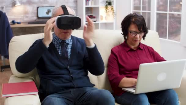 Idős pár, akik modern technológiával nézik a filmeket — Stock videók