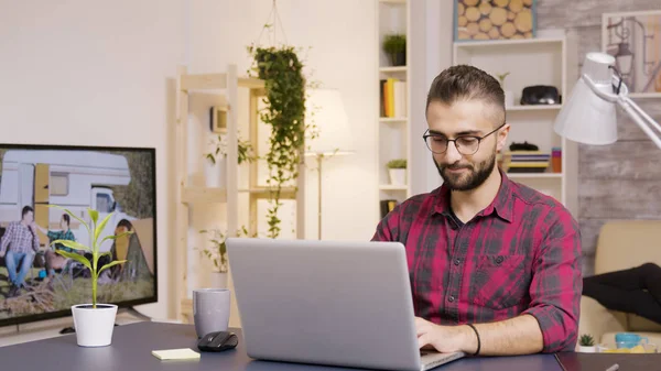 Freelancer tomando un sorbo de café mientras trabaja en el portátil — Foto de Stock