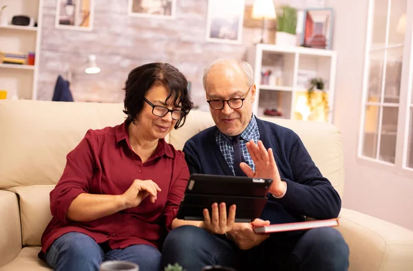 Mooi oud paar met behulp van een digitale tablet om te chatten met hun familie — Stockfoto