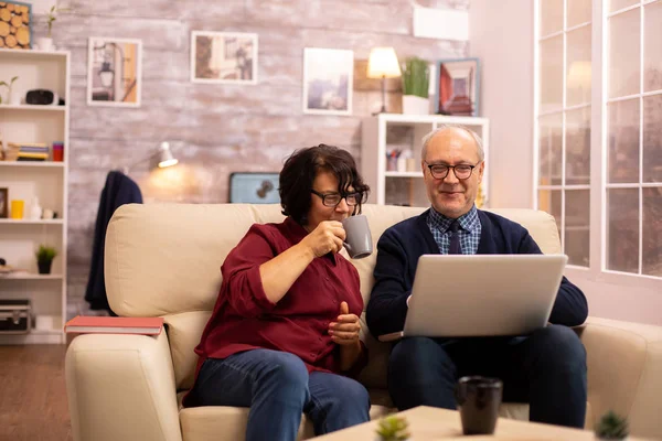 Ouderen oude paar met behulp van moderne laptop om te chatten met hun kleinzoon — Stockfoto