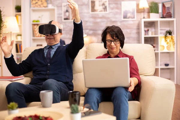 Idoso idoso aposentado homem usando realidade virtual headset em seu aconchegante apartamento — Fotografia de Stock