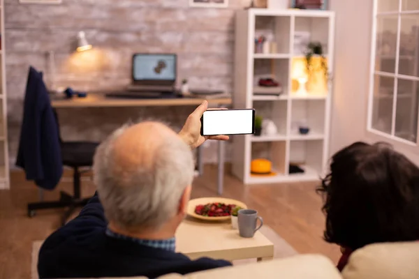 Zadní pohled na starší důchodce pár při pohledu na smartphone s bílou izolovanou obrazovkou — Stock fotografie