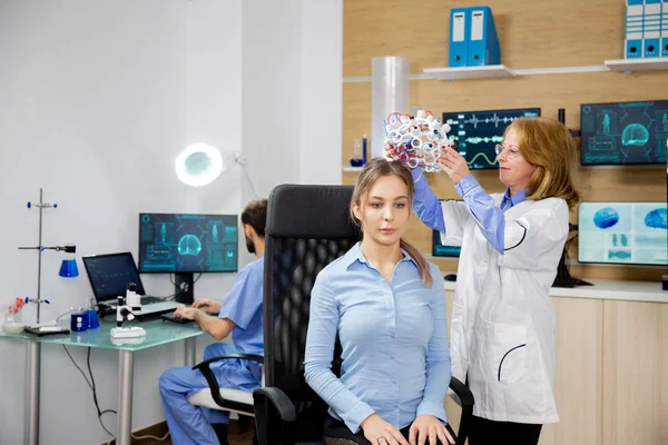 Лікар кладе гарнітуру сканування мозкових хвиль на пацієнта жінки — стокове фото