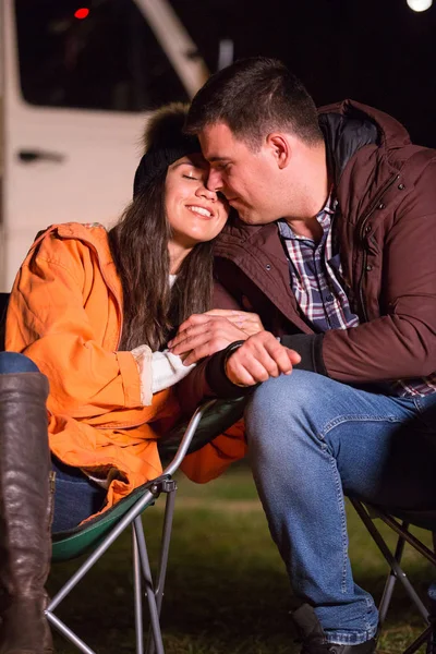 Beautiful couple sharing a sweet moment on the wormth of camp fire — Stock Photo, Image